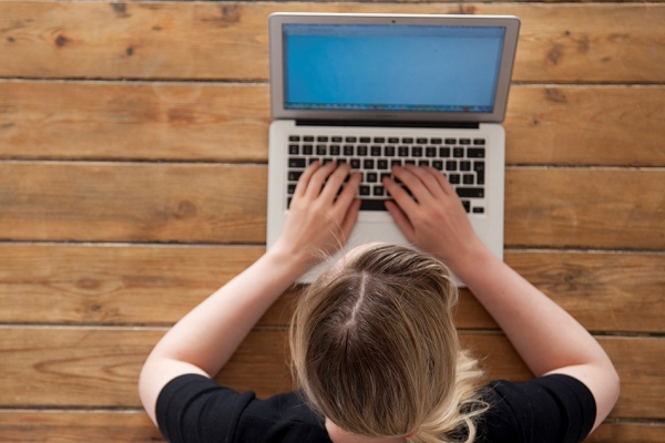 Overhead view of woman typing on laptop