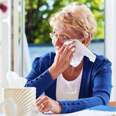 Older lady wiping her tears with a tissue