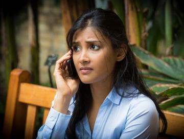 a lady on a phone call looking concerned