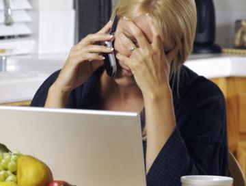 a lady on a phone call looking concerned and hands on her forehead