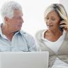 A couple browsing on their laptop while on a phone call