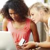 two women's trying to make an online payment on their laptop 